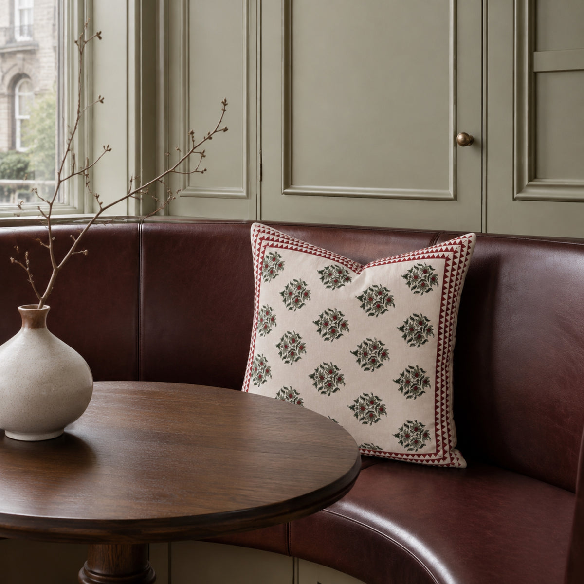 Red Berry Sprig Cushion Cover, styled in a seating or bedroom setting.