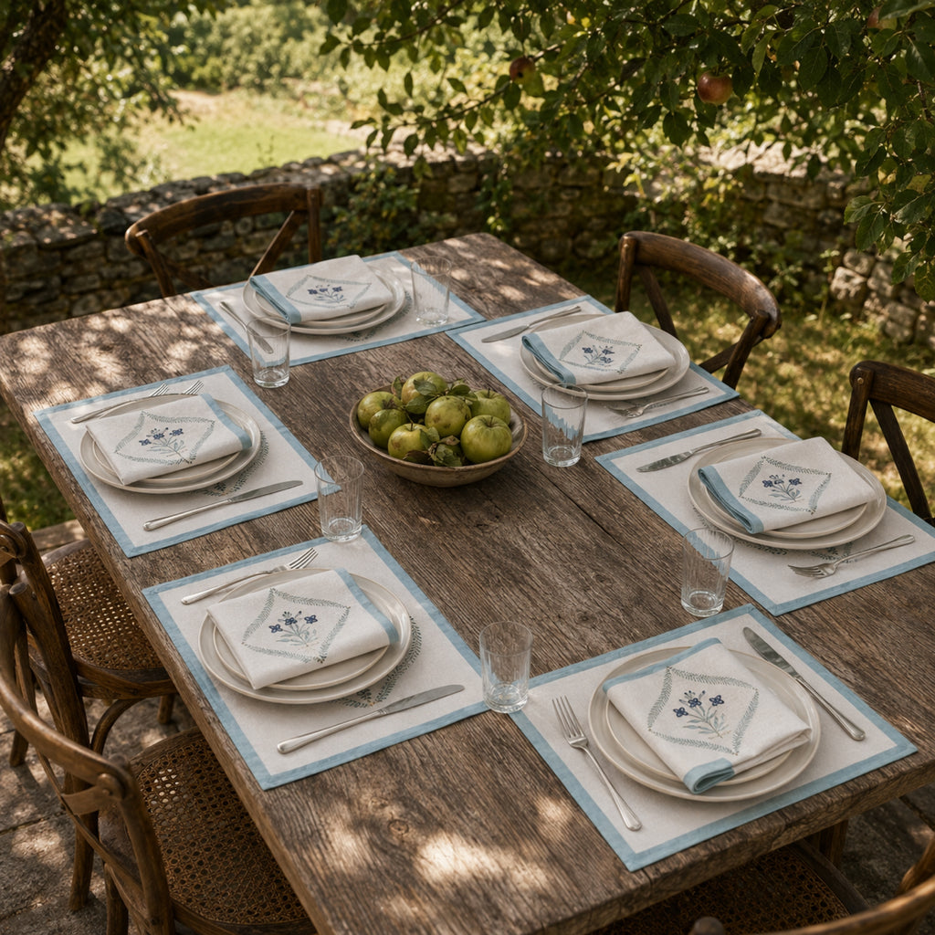 Powder Blue Botanical Wreath Mat & Napkin Set, styled on a dining table.