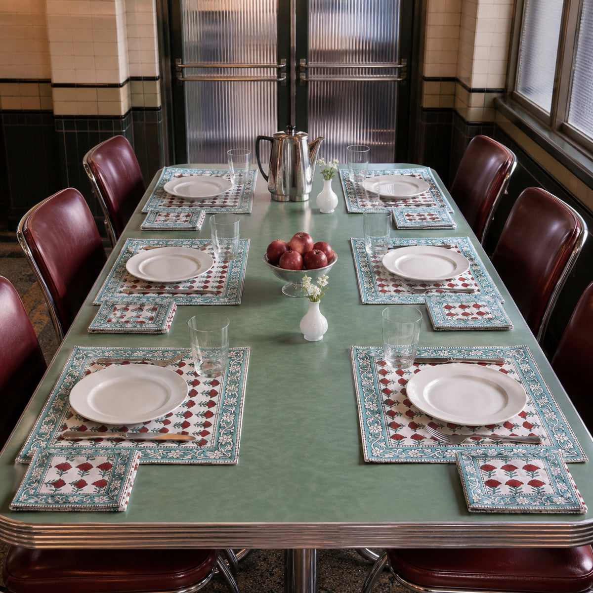 Red Marigold Aqua Border Mat & Napkin Set, styled on a dining table.