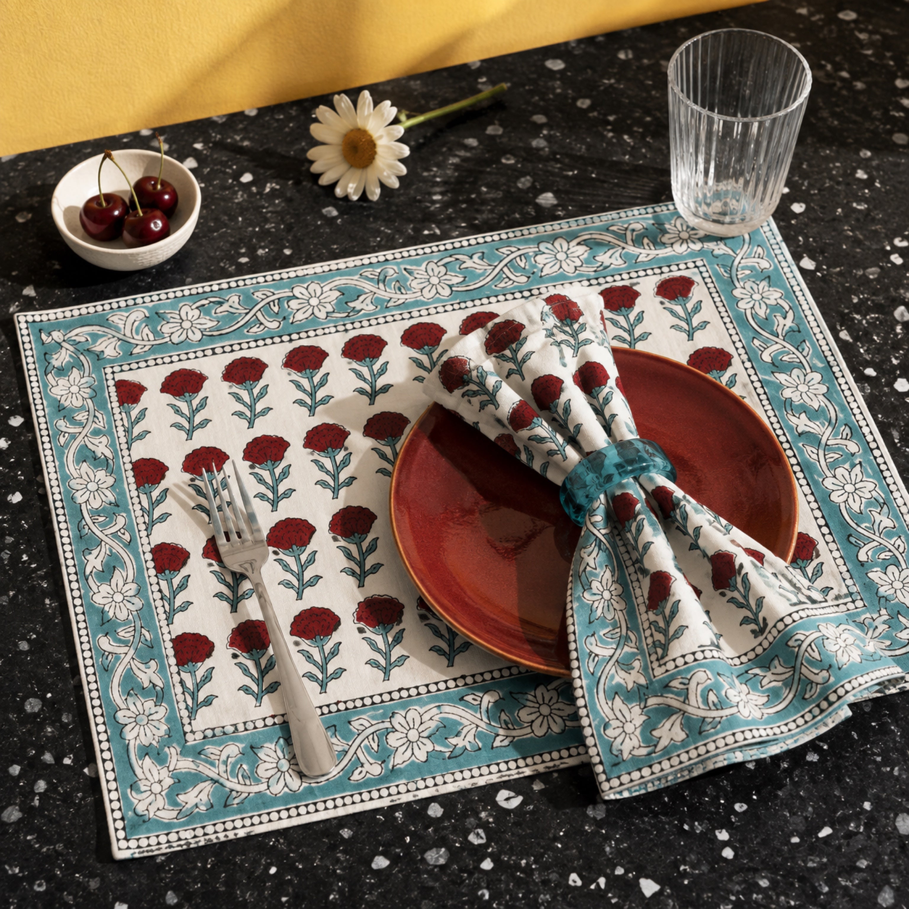 Red Marigold Aqua Border Mat & Napkin Set, styled on a dining table.