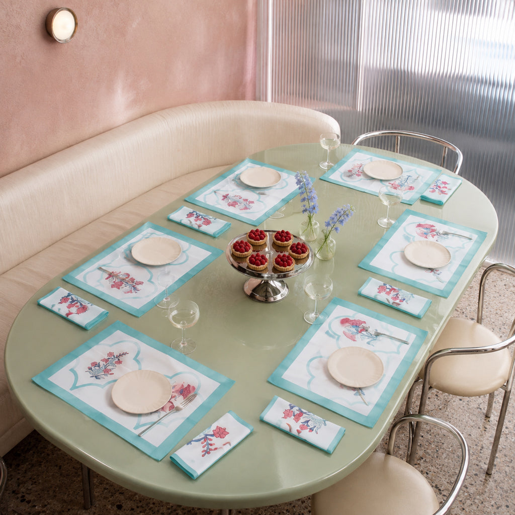 Aqua Scallop Coral Botanical Mat & Napkin Set, styled on a dining table.