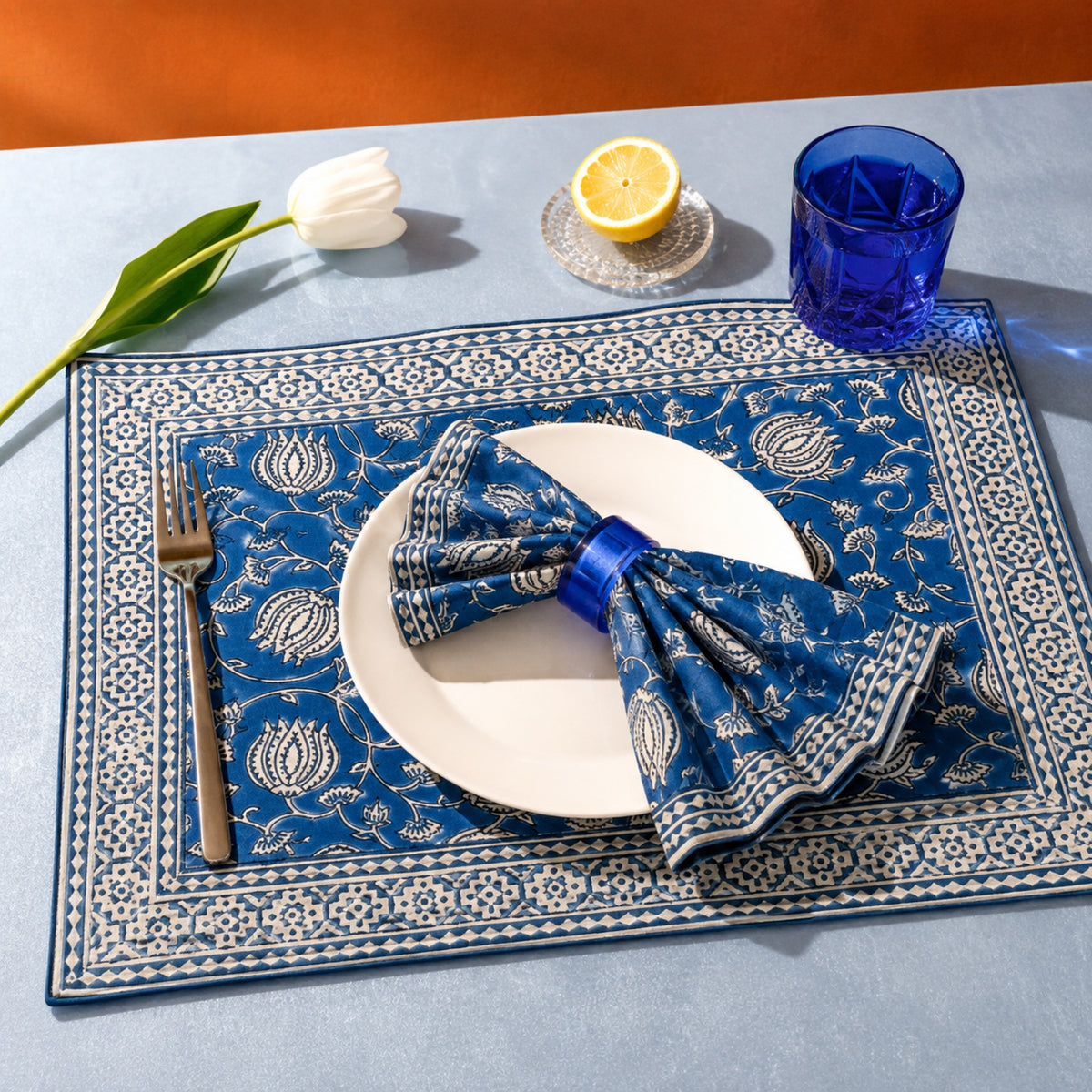 Cobalt Lotus Mat & Napkin Set, styled on a dining table.